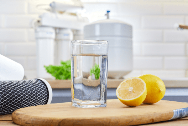 A fresh glass of water placed in front of a reverse osmosis system, demonstrating fluoride removal for improved water quality.