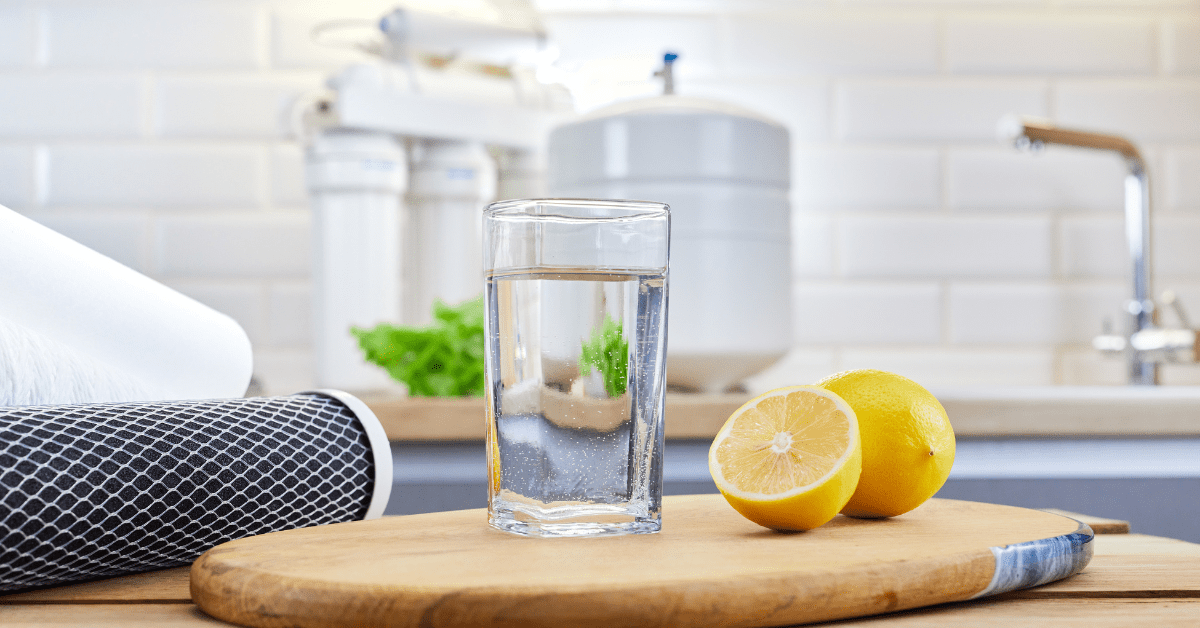 A fresh glass of water placed in front of a reverse osmosis system, demonstrating fluoride removal for improved water quality.