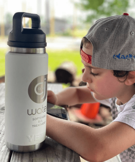 Child using a tablet at a picnic table.