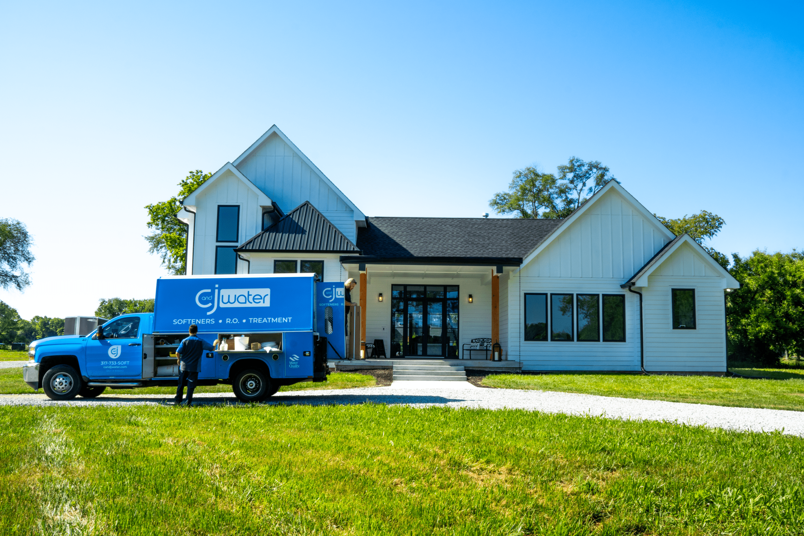 C and J Water service truck parked outside a rural home for water softener or filtration system service